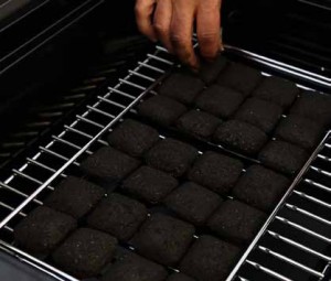 Placing charcoal briquettes on grate